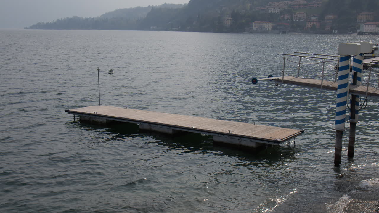 Floating Dock, Floating Wooden Platform In The Lake Como In Menaggio Town in Italy, wide shot