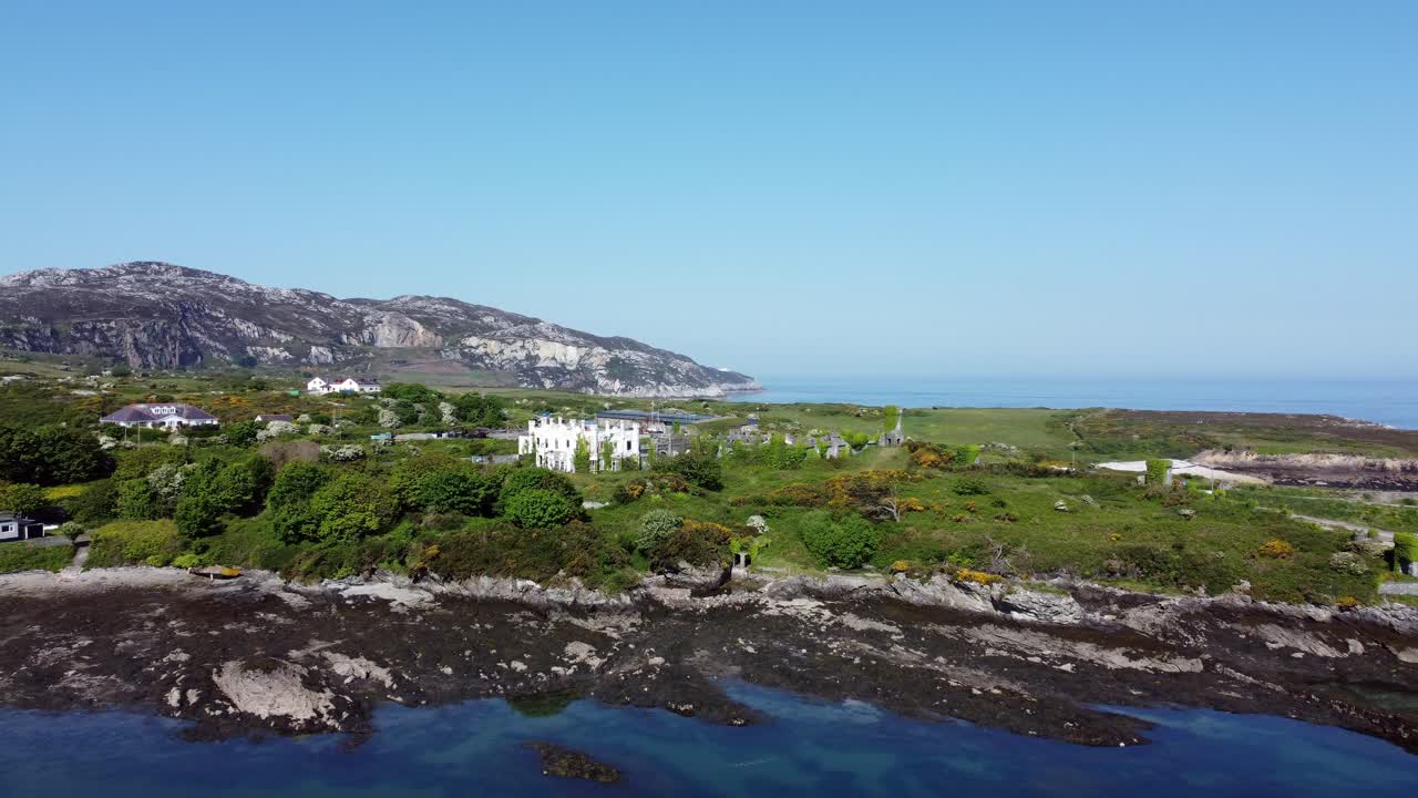 군인들은 역사적인 홀리헤드 방파제 웨일스 산의 버려진 해안 유적지를 향해 집의 조감도를 가리키고 있습니다.