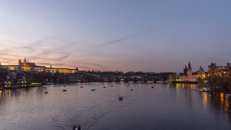 Timelapse-De-4k-De-Botes-De-Remo-En-El-Río-Vltava-En-Praga-Con-El-Castillo-Y-El-Puente-De-Carlos-En-El-Fondo,-Zoom-En-La-Vista