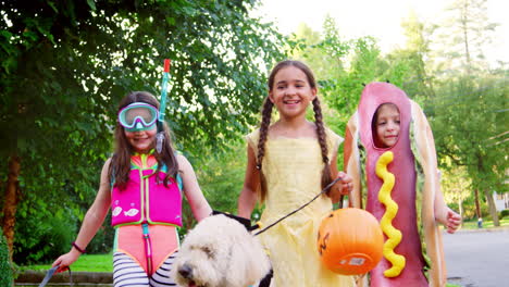 children and dog in halloween costumes for trick or treating
