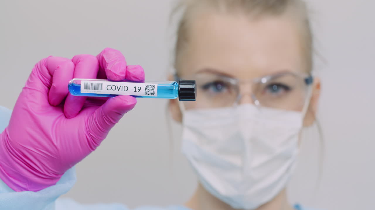 investigador sosteniendo el tubo de muestra covid 19 en la mano 1