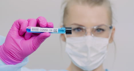 researcher holding covid 19 sample tube in hand 1