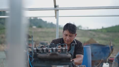 man repairing a tractor engine