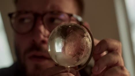 person looking at a miniature globe