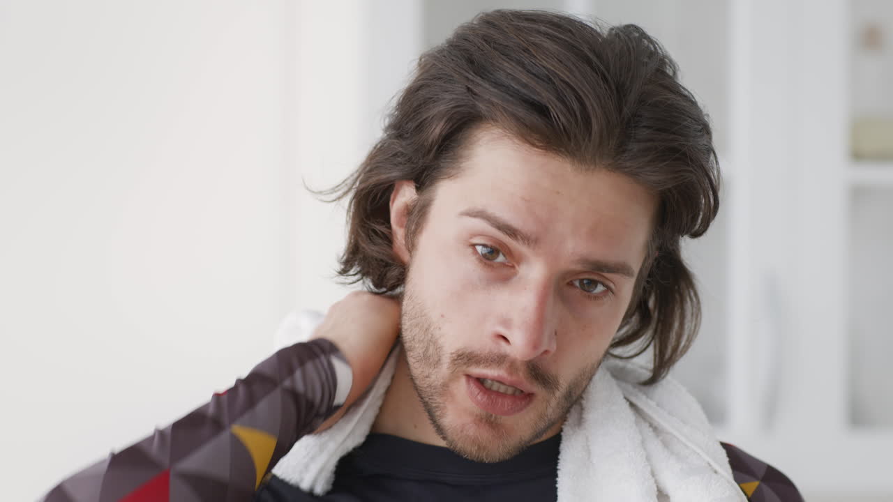 hombre limpiando el sudor con una toalla después del ejercicio