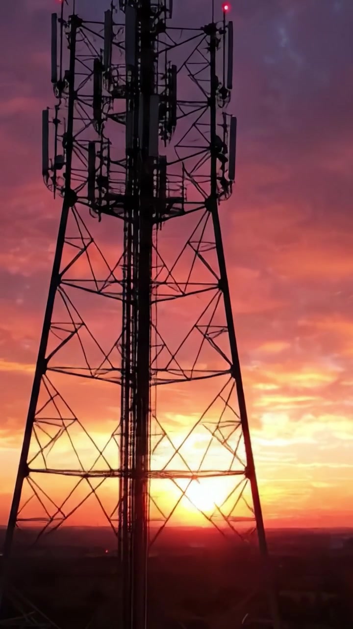 Splendide Viste al Tramonto con Strutture a Torre Sagomate Contro un Cielo Vivido Arancione e Viola in Transizione dal Giorno alla Notte