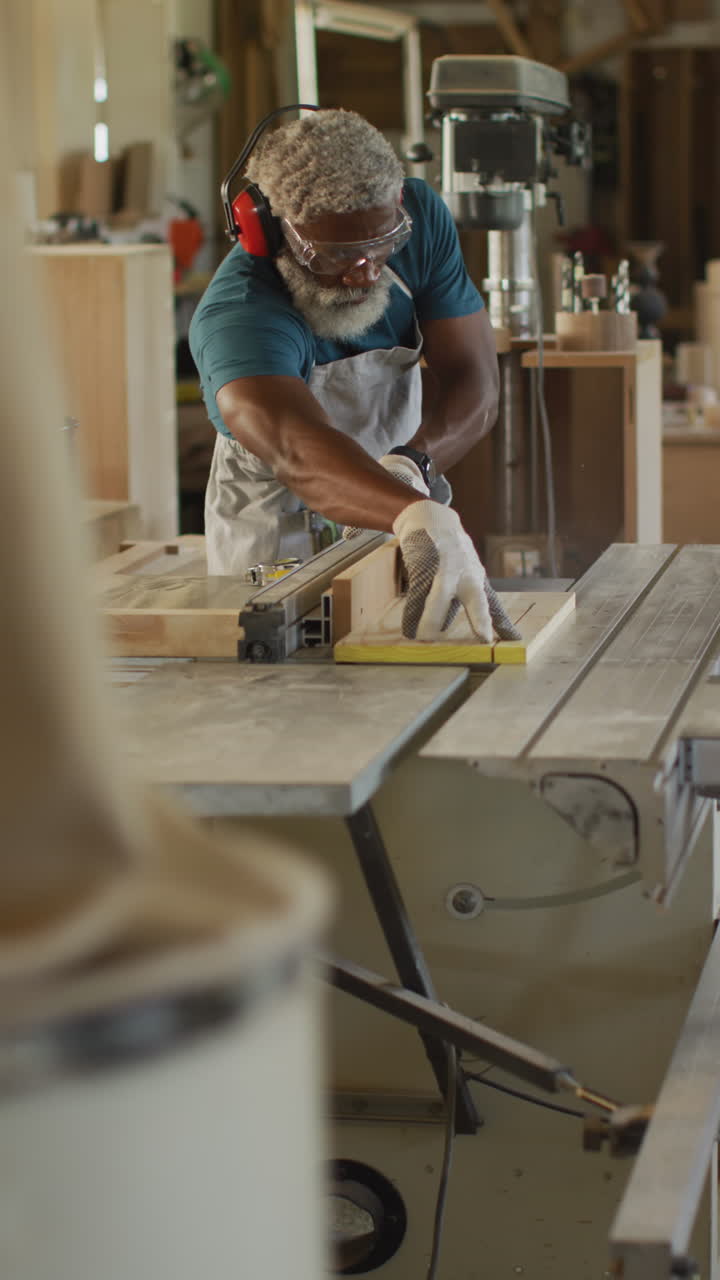 video vertical de un carpintero afroamericano de edad avanzada trabajando en un taller