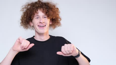 curly redhaired young man on a blue background with a toothy smile carelessly dancing curly redhaired young man on a blue background with a toothy smile carelessly dancing moves to the rhythm of the music