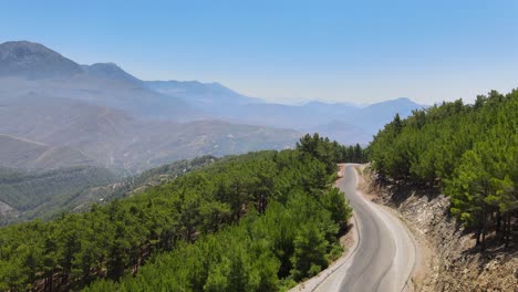 Aerial-drone-passing-across-a-highway-road-in-the-rural-Taurus-Mountain-landscape-of-Antalya-Turkey-on-a-sunny-summer-afternoon