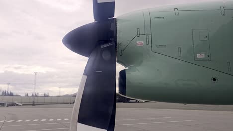 looking out window of parked twin propeller aircraft at norwegian airport as propeller slows down