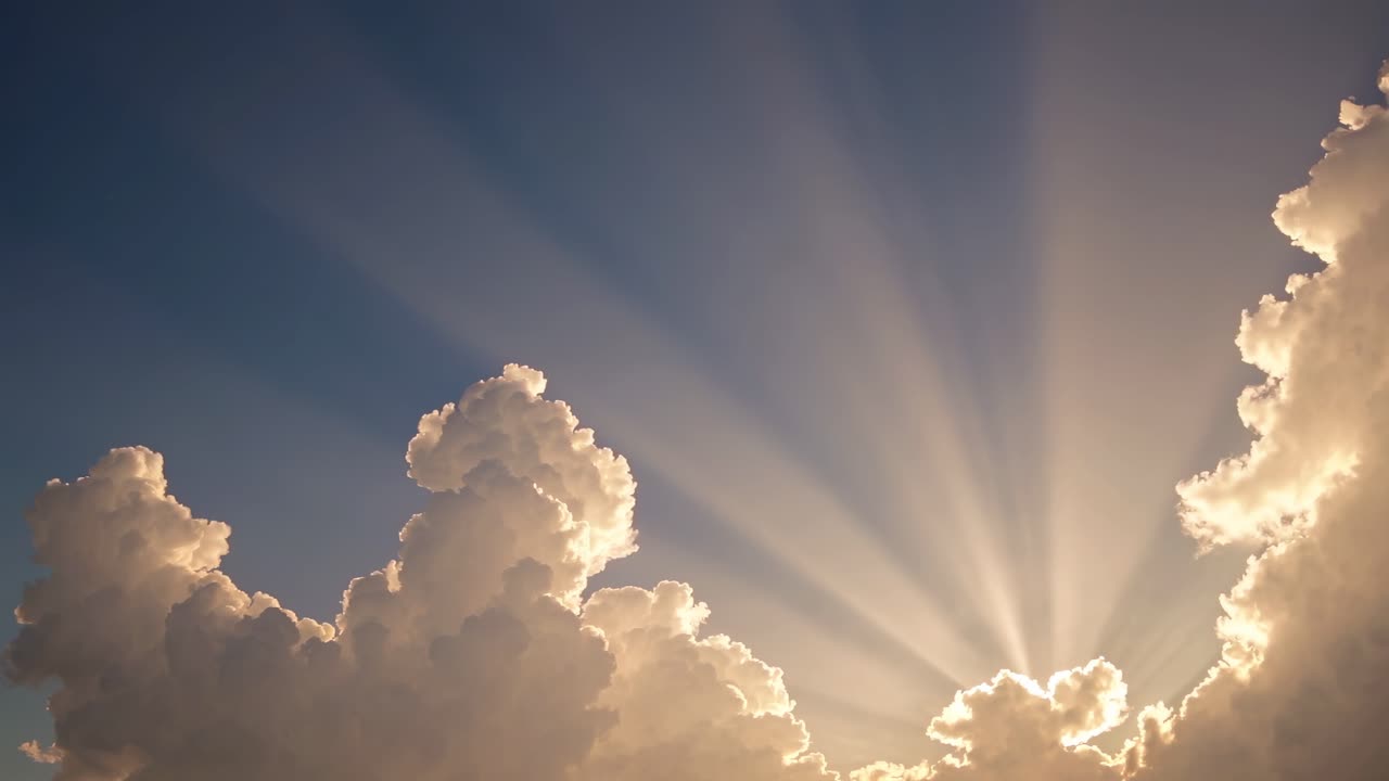 A breathtaking video captures the sun's rays streaming through fluffy clouds at a low angle