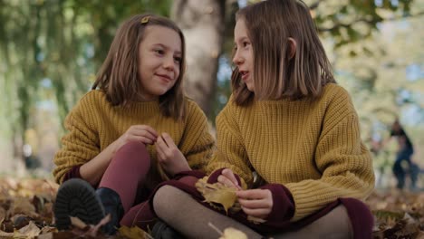 two siblings sister sitting in the park and talking together.