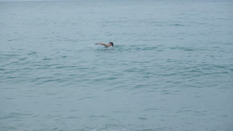 Man-Swims-and-Dives-into-Sea-During-Gray-Day