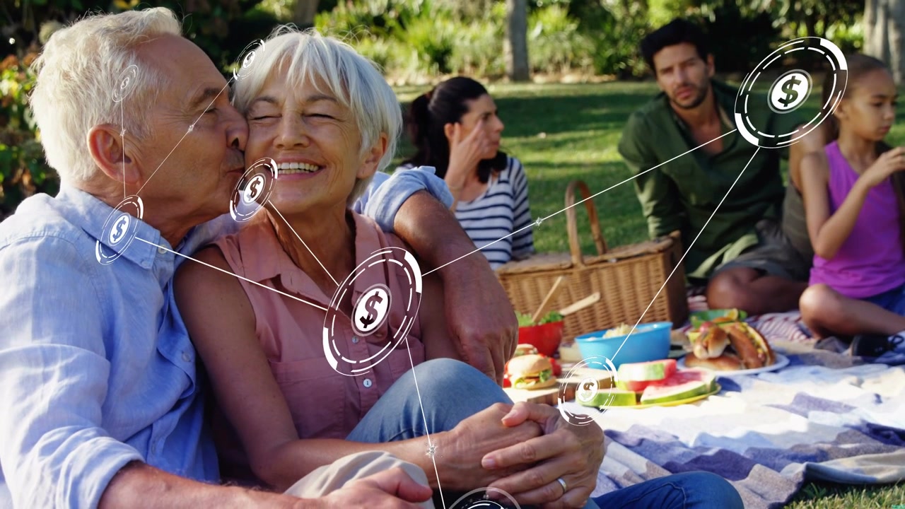 Senior couple kissing and leaning, starting finance overlay of dollar nodes across picnic blanket