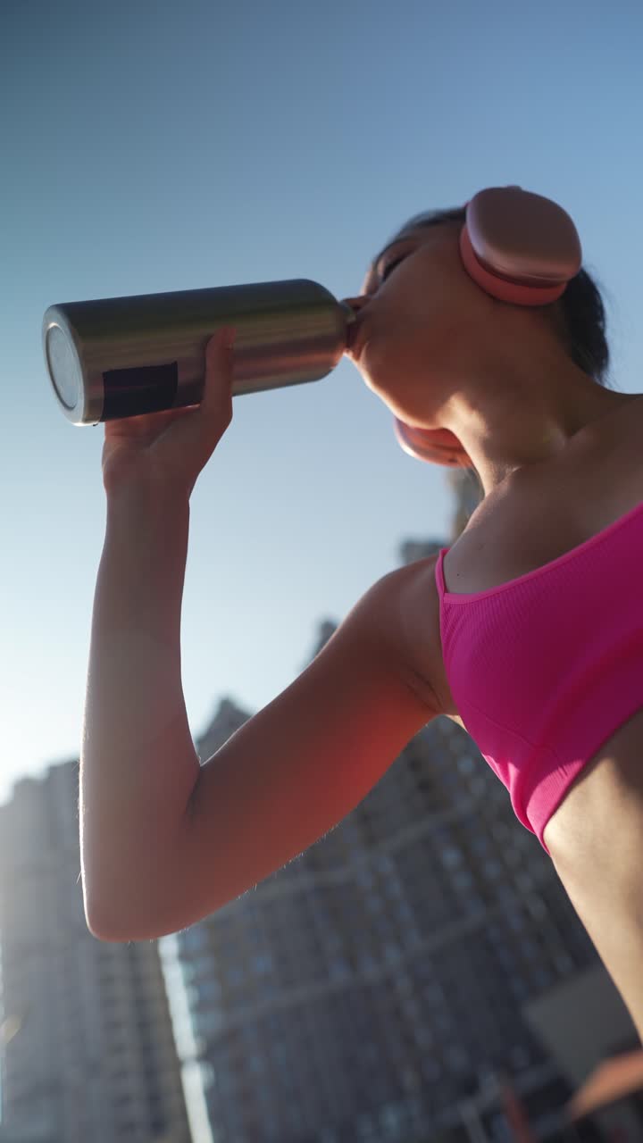 mujer bebiendo agua después del entrenamiento