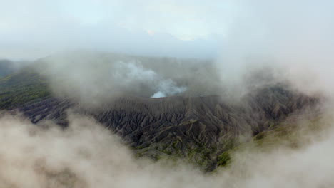 mount bromo, flying threw clouds to reveal active east java volcano, indonesia