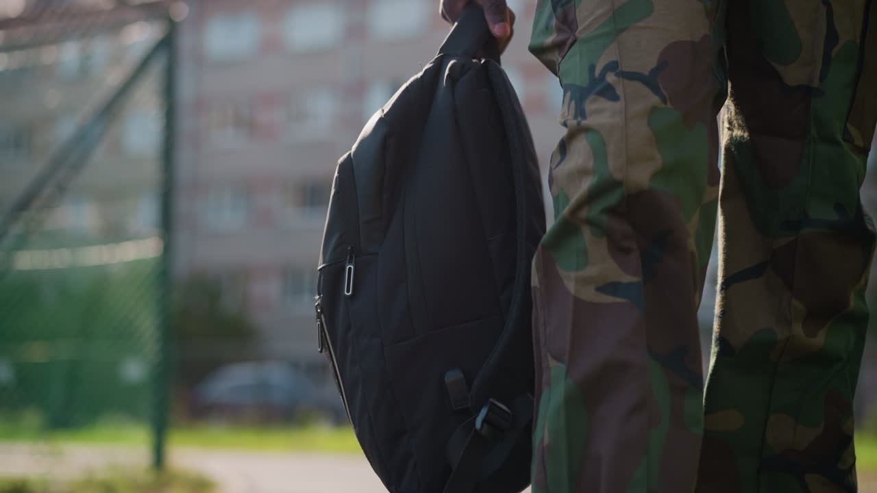 Soldier With Bag, Quiet Soldier Departs On City Sidewalk, Solitary Military Figure Embraces Calm Urban Environment Farewell, Lone Serviceman Clutches His Bag In Peaceful City Farewell Scene
