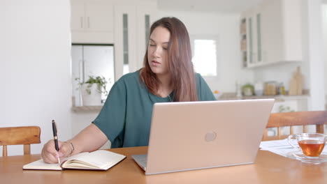 Montage-of-happy-plus-size-biracial-woman-working,-eating-and-exercising-at-home,-slow-motion