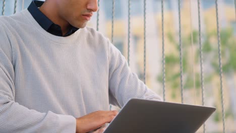 Man-checking-smartwatch-while-using-laptop-4k