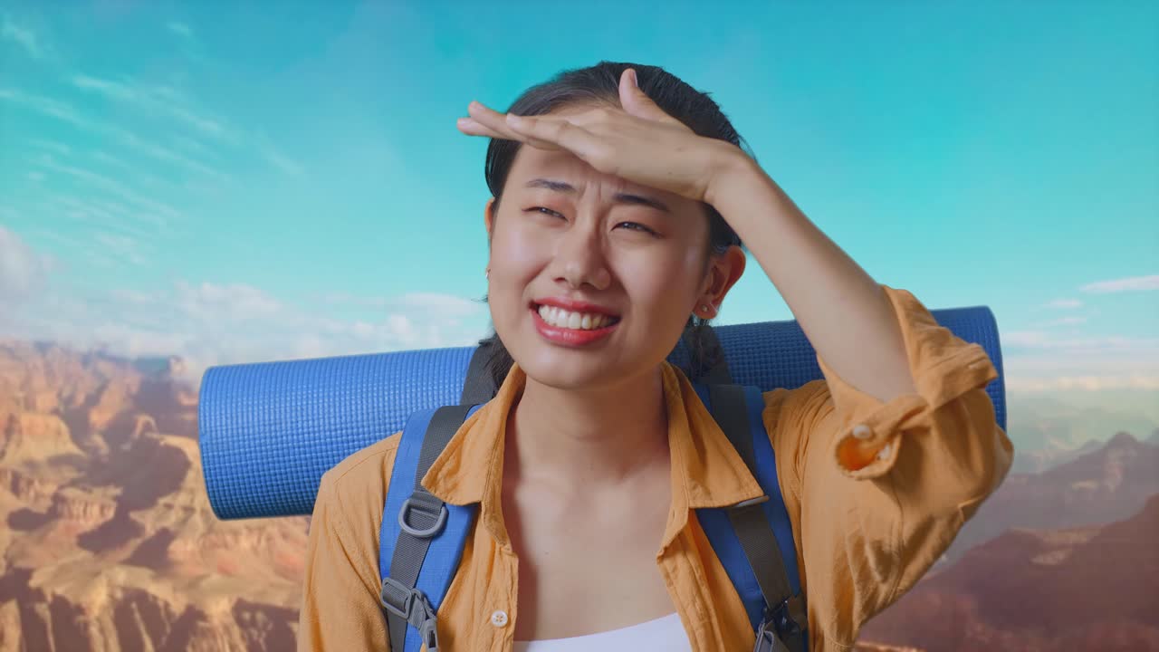 Close Up Of Asian Female Hiker With Mountaineering Backpack Hand Forehead Smiling And Looking Distance While Traveling At The Top Of Mountain