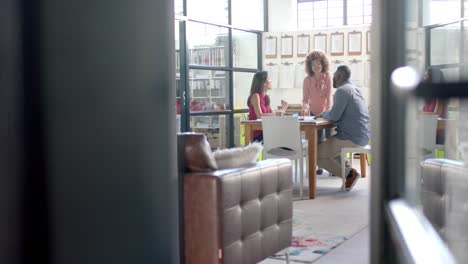 Busy-diverse-architects-discussing-blueprints-on-table-in-office,-copy-space,-slow-motion