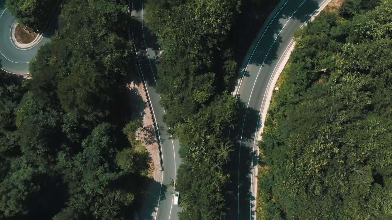 구불구불한 산비탈 길을 달리는 자동차를 4K 항공 촬영한 영상