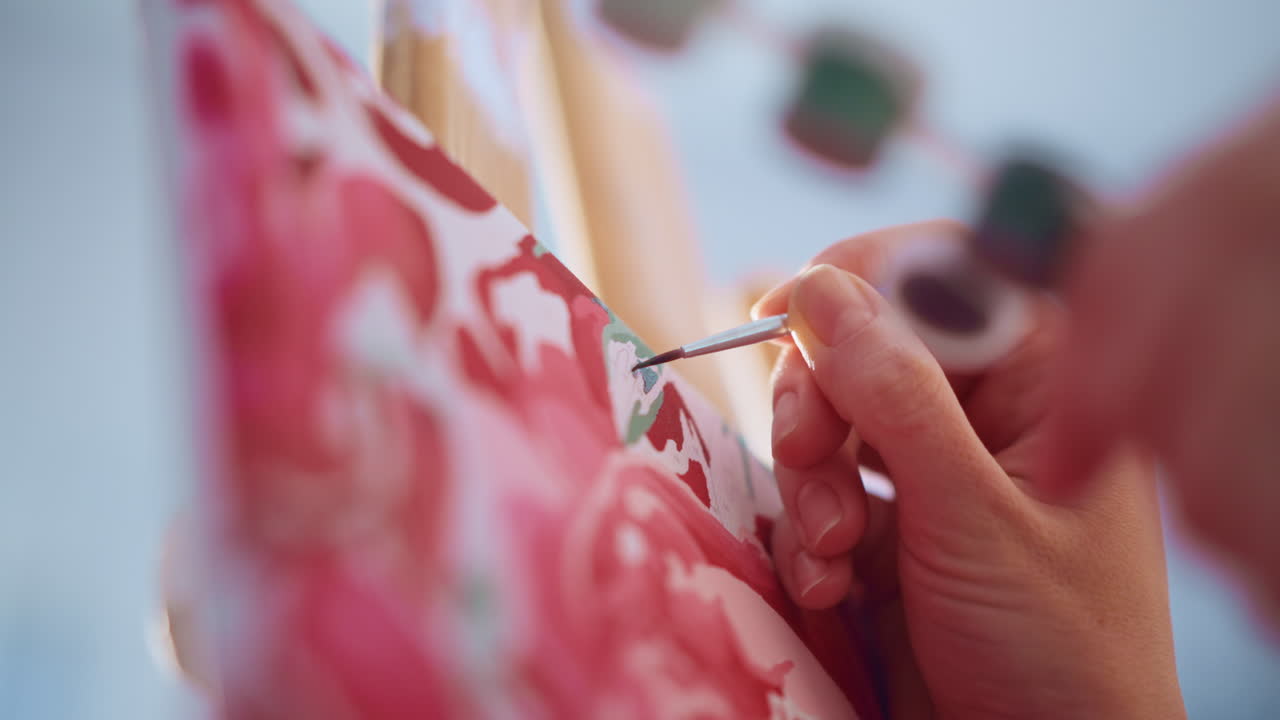 Tight Shot Brush Applying Green Leaf Strokes On Rose Canvas, Professional Illustrator Refining Edges At Easel In Bright Studio Precise Wrist Control, Thin Filbert Brush, And Crisp Highlights