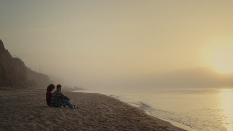 young woman and man spending vacation at ocean. couple having date on beach