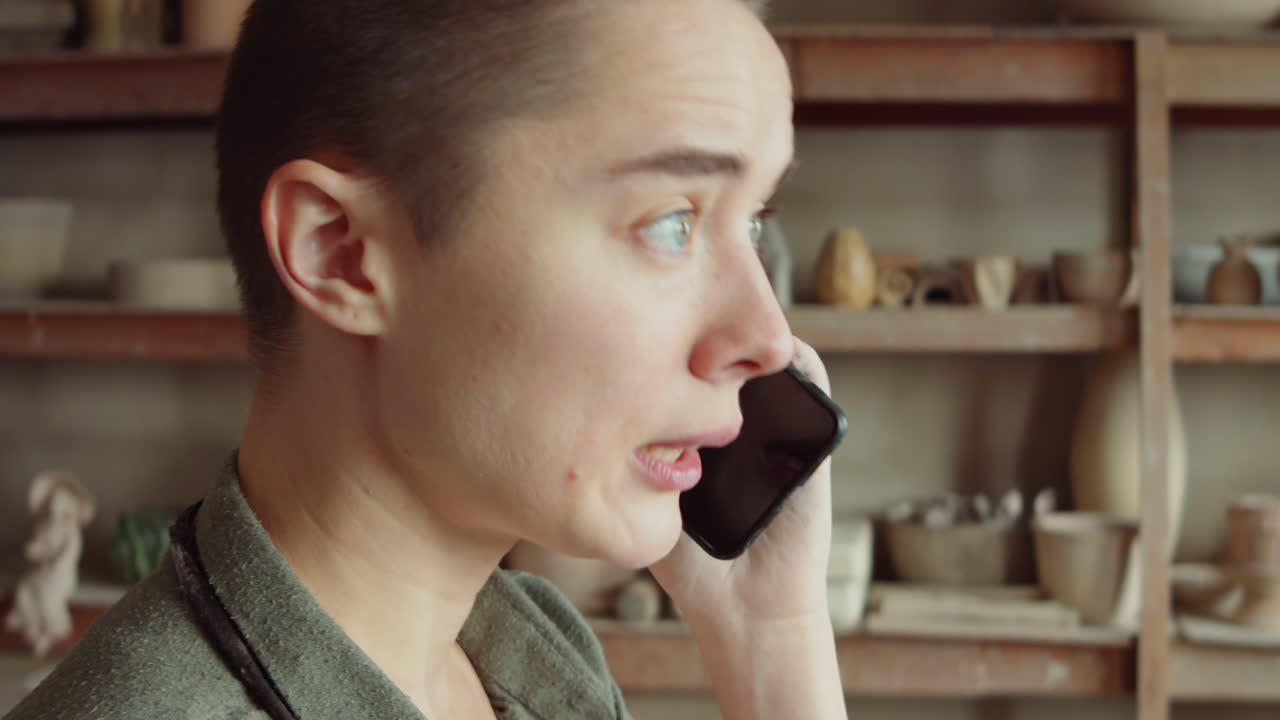 도자기 스튜디오 에서 전화 로 이야기 하는 여자