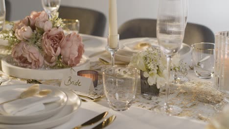 close up of table set for meal at wedding reception with place cards for bride and groom 1