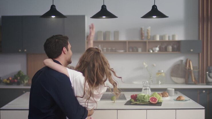 Giovane coppia che balla insieme in cucina