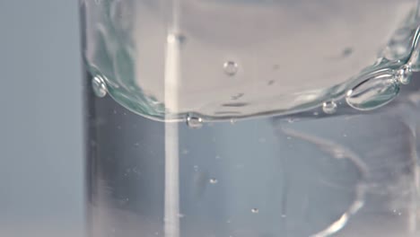 ice cubes falling into glass of water