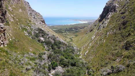 birds-eye-shot-of-Bettys-Bay-and-flying-in-between-two-hills