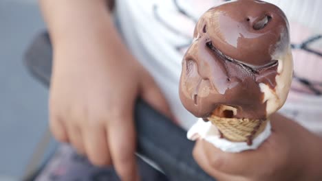 child eating melted chocolate and vanilla ice cream