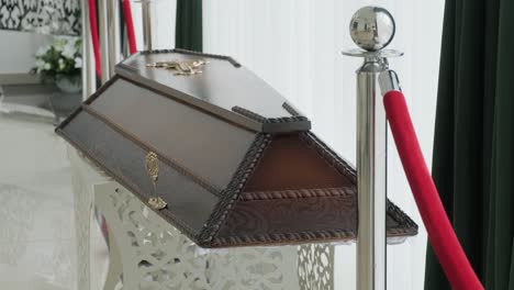 ceremonia de funeral. el ataúd en la capilla funeraria. rosa de la iglesia, flores funerarias. concepto de funeral y luto. ataúd de madera marrón en la iglesia.