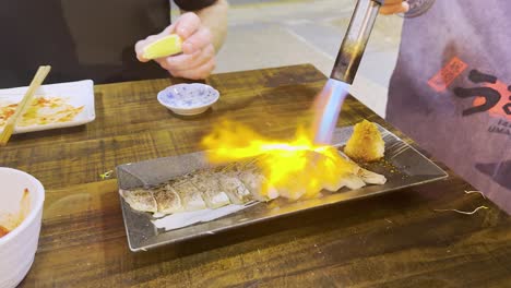 chef uses blowtorch to sear fish fillets