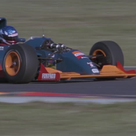 un coche de carreras se mueve rápidamente por una pista