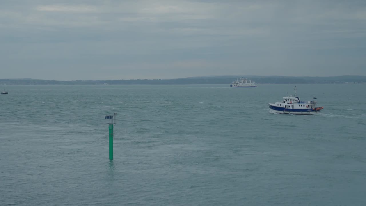 배는 구름이 많은 날 배경에 와이트 섬과 함께 채널에서 항해합니다.
