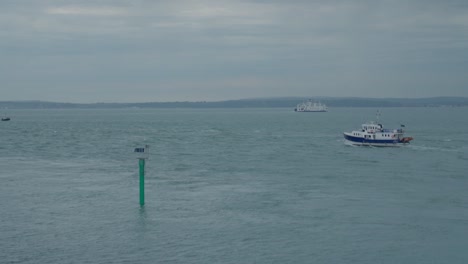 los barcos navegan por el canal con la isla de wight en el fondo en un día nublado