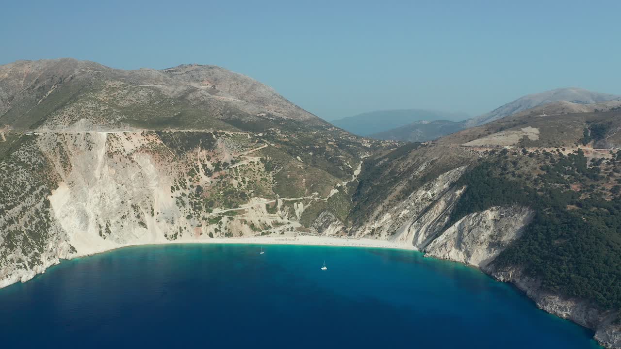 Myrtos beach, natural cliff bay, Emerald sea in Kefalonia island, Aerial Pullback