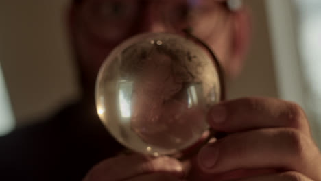 person looking through a glass sphere