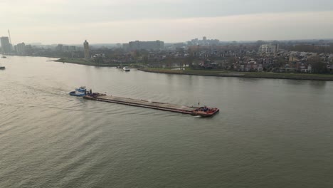 aerial view over cargo vessel gliding through water channel in dordrecht, netherlands