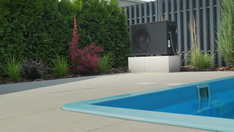 una pequeña piscina, al lado de ella es visible una bomba de calor para calentar el agua. tecnologías de ahorro de energía