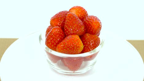 fresh, ripe, red strawberries in rotating bowl