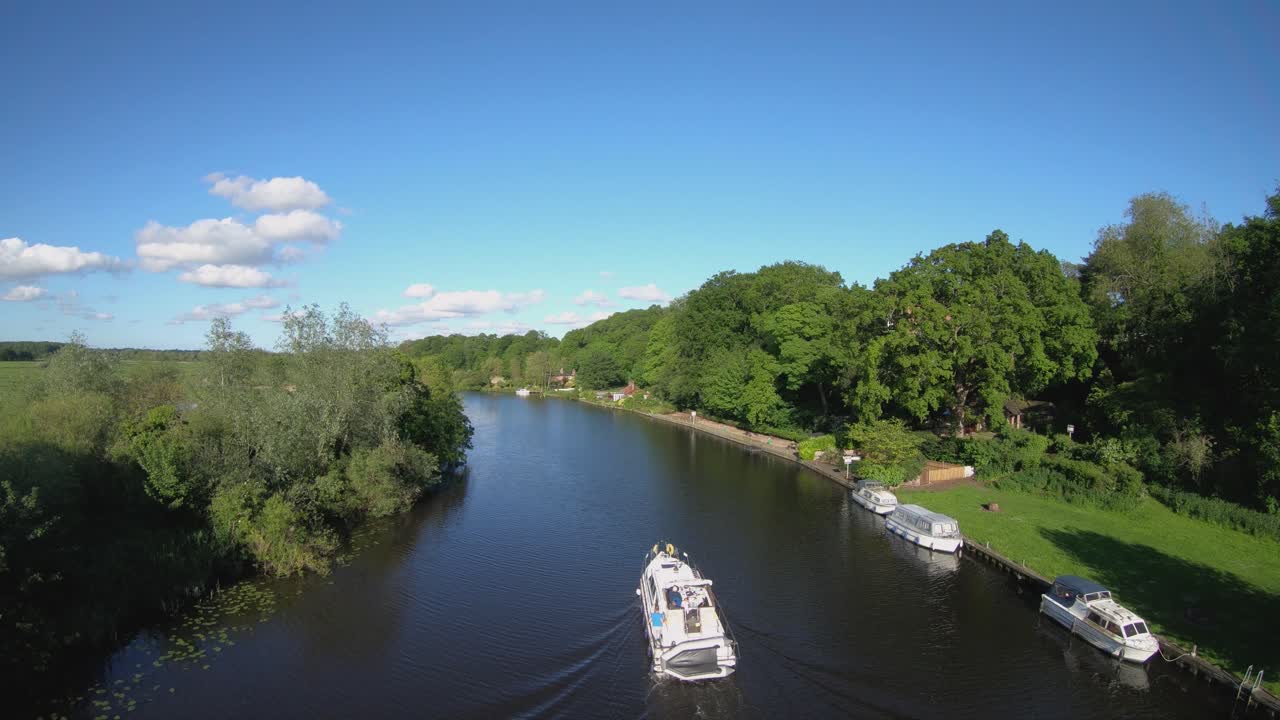 Imagens aéreas de drone de um barco navegando ao longo do Rio Yare, Norfolk.