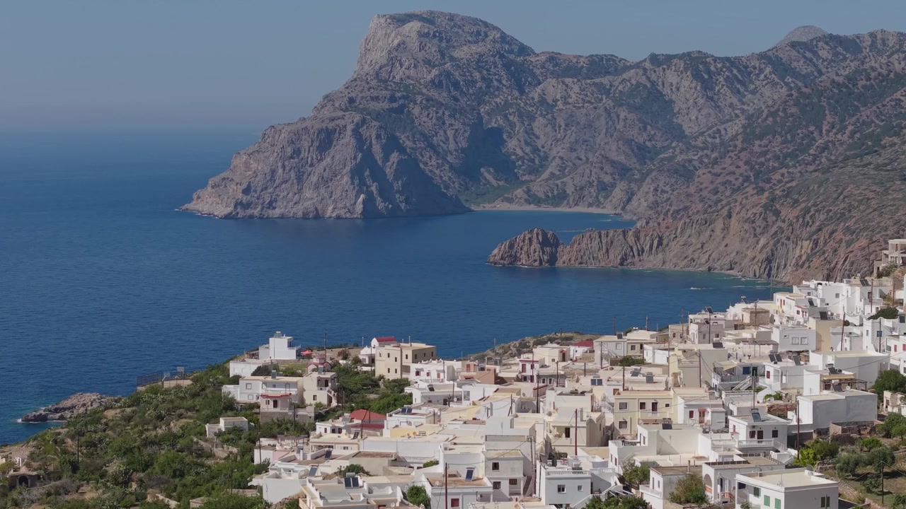 Karpathos'taki Mesochori Köyü üzerinde yanal drone uçuşu, adanın engebeli dağları ve muhteşem doğal manzarasına karşı geleneksel tepe yerleşimini gözler önüne seriyor
