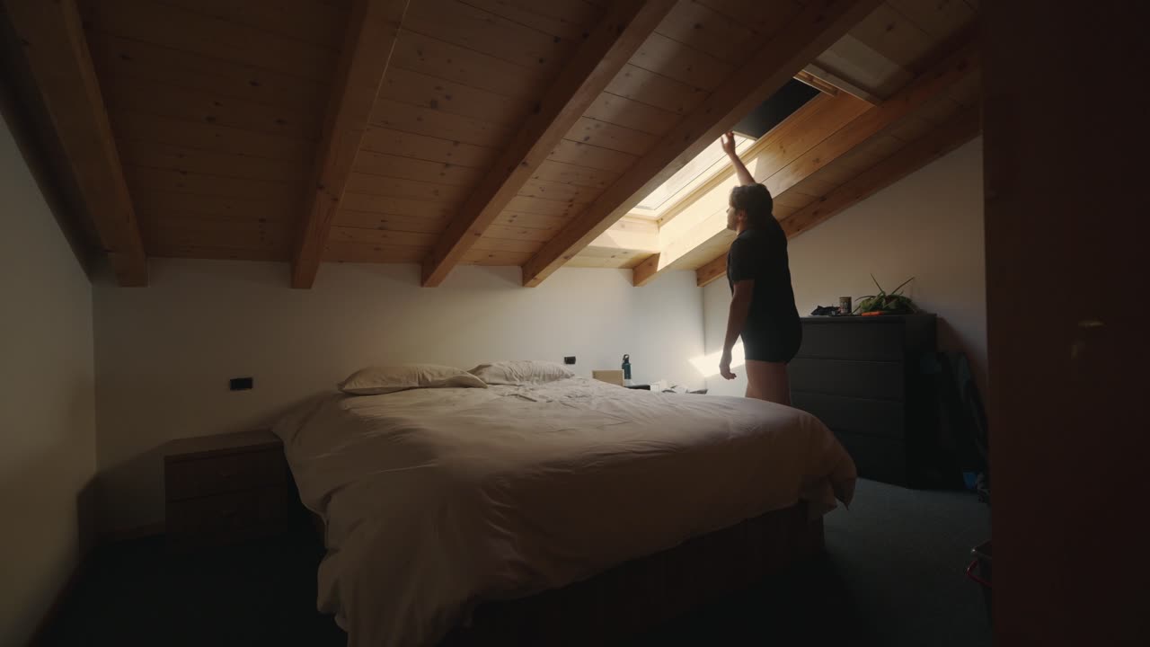 hombre entrando en el dormitorio y cerrando la tienda de velux haciendo oscuro