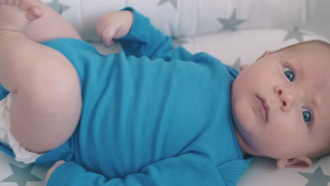 adorable-boy-with-bare-legs-lie-in-comfortable-baby-cocoon