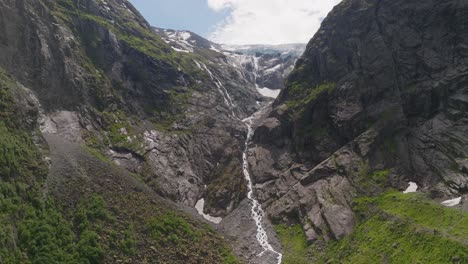 Majestic-glacier-valley-with-flowing-waterfall-at-Jostedalsbreen-Glacier,-Norway