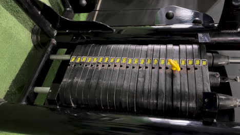 detail of man performing weight changes on gym equipment